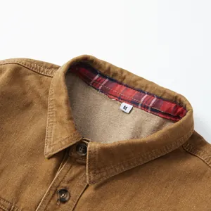 Détail du col d'une chemise en jean marron avec doublure à carreaux et taille M