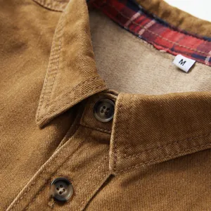 Gros plan du col d'une chemise en jean marron avec doublure à carreaux et boutons