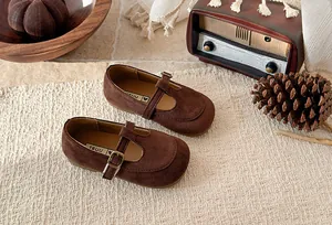 Vintage style brown suede T-strap Mary Jane shoes for girls shown in a rustic lifestyle setting