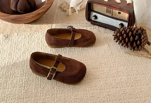 Detailed macro view of brown suede T-strap Mary Jane shoes for girls in vintage setting