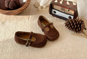 Detailed view of brown suede T-strap Mary Jane shoes for girls in a vintage setting.