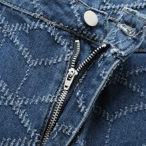 Détail d'une fermeture éclair en métal et d'un jean en denim bleu avec motif à losanges texturé