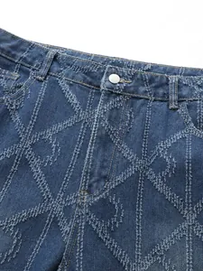 Close-up detail of denim jeans with distinctive frayed diamond pattern texture and button