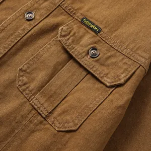 Vue détaillée de la poche et des coutures sur une chemise en jean marron classique pour homme.