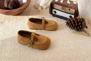 Detail view of vintage brown suede girls T-strap Mary Jane shoes with metal buckle