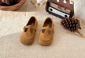 Vintage brown suede T-strap Mary Jane shoes for girls with retro prop background
