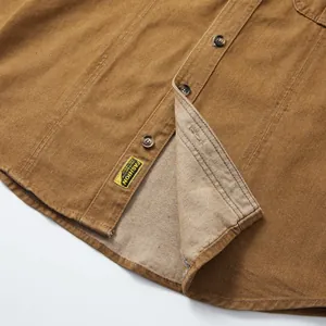 Vue détaillée d'une chemise en jean marron pour homme montrant le tissu et les boutons