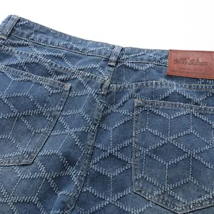 Vue détaillée du jean bleu pour homme avec motif en losange usé et patch en cuir au dos