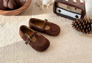 Vintage brown suede T-strap shoes for girls displayed in a cozy and rustic home setting