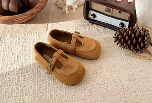 Detailed view of girls' brown suede T-strap Mary Jane shoes in a vintage setting.