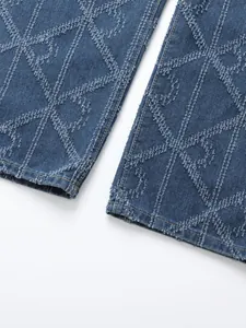 Close-up of men's blue denim jeans featuring unique frayed diamond geometric patterns.