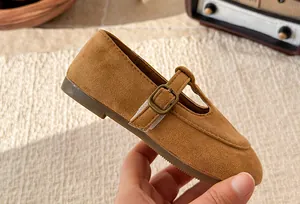 Close-up view of girls' brown suede Mary Jane shoe with a vintage T-strap buckle design