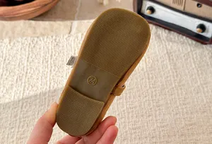 Close-up showing the non-slip rubber sole and size 24 on brown girls' T-strap shoes