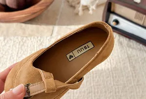 Close-up of brown suede girl's Mary Jane shoe featuring T-strap buckle and soft insole