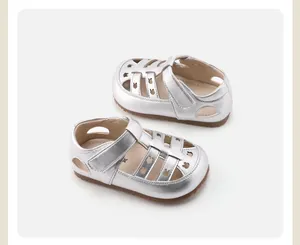 Detalle de sandalias plateadas para niños con patrones de conejos calados y suelas de goma.