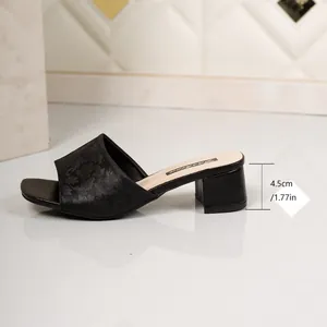 Close-up view showing the 4.5cm block heel of this elegant black floral slide sandal