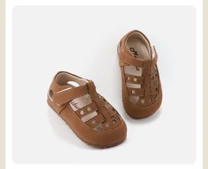 Primer plano de sandalias marrones para niños con recortes de conejos y suelas blandas.