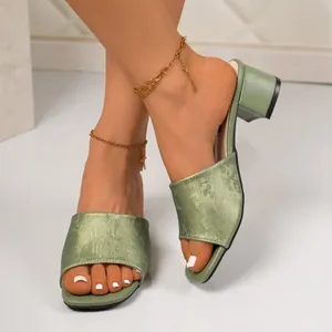 Detail view of sage green block heel sandals featuring elegant floral jacquard fabric