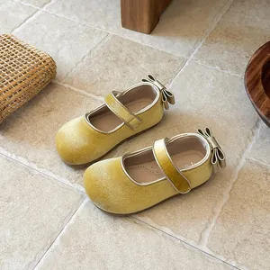 Top-down detail of yellow velvet girls Mary Jane shoes featuring a cute back bow