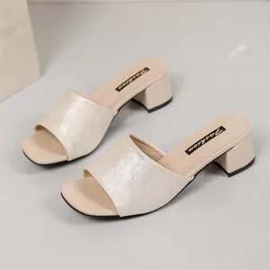 Elegant cream block heel slide sandals featuring an embossed floral pattern detail