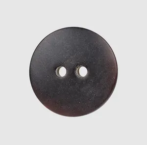High-quality macro view of a dark brown natural horn button featuring a classic 2-hole design