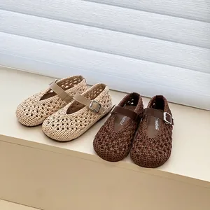 Detailed view of woven Mary Jane girl's sandals in beige and brown with adjustable buckles