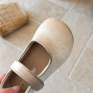 Macro view of champagne velvet Mary Jane shoe for girls showing strap and texture