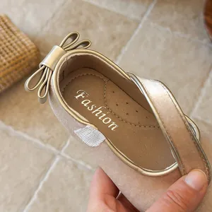 Close-up of velvet girl's princess shoe showing the gold bow detail on the heel.