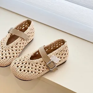 Close-up detail of beige hollow woven girl sandals featuring an adjustable buckle strap