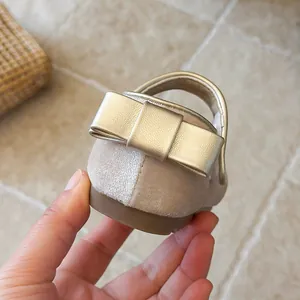 Macro view of elegant beige velvet girls princess shoe featuring gold bow detail