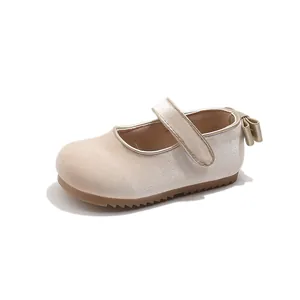 Detailed view of champagne velvet toddler girl's Mary Jane shoe with heel bow accent.