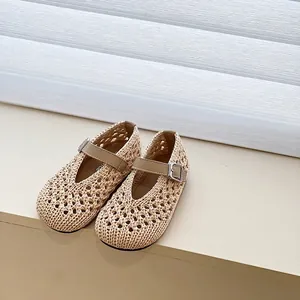 Close-up of beige woven girls' hollow-out sandals featuring adjustable buckled straps