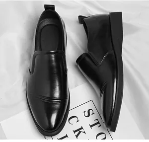 Detailed close-up shot of men's black leather business dress shoes on white backdrop