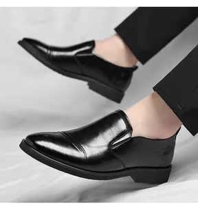 Detailed view of black slip-on business leather shoes worn with formal black trousers