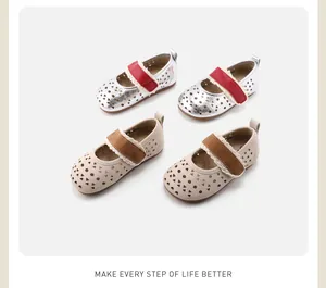 Detailed view of hollow patterned children's Mary Jane shoes in silver and beige colors