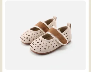 Macro view of beige toddler girl's perforated Mary Jane shoes with delicate lace trim.