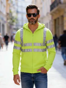 Nahaufnahme eines gelben Warnschutz-Hoodies mit Sicherheitsreflexstreifen auf Straße