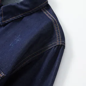 Macro view of dark blue denim shirt showing shoulder stitching and premium texture