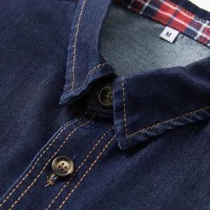 Close-up of dark blue denim shirt collar with plaid lining and size M tag detail