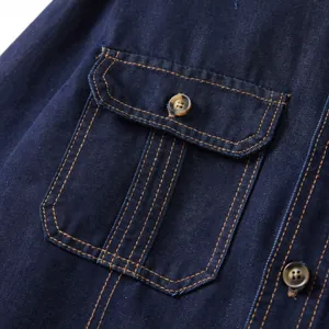 Close-up of a dark blue denim shirt pocket with flap and contrast yellow stitching