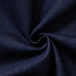 Close-up of dark blue denim fabric texture showing twill weave and drape