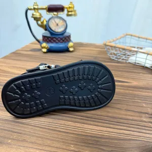 Close-up of non-slip rubber sole for black girl's sandals with floral tread