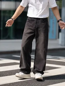Close-up detail of men's loose straight-leg retro washed charcoal denim jeans on street