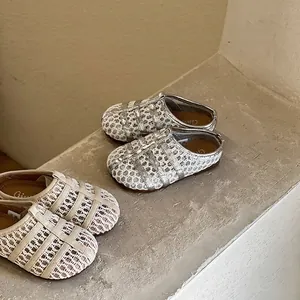 Détail de sandales ajourées tissées pour filles avec semelles souples argent et beige