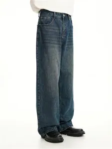 Detailed view of men's loose straight-leg washed vintage denim jeans in blue color