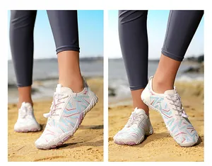 Detailed view of unisex barefoot water shoes with patterned upper on a sandy beach