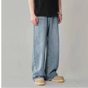 Detailed lower body shot of men's loose straight-leg washed blue retro denim jeans