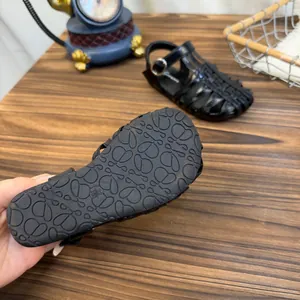 Gedetailleerd overzicht van de antislip rubberen zool van zwarte geweven sandalen voor meisjes