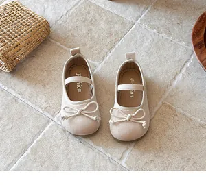 Vista superior de zapatos de princesa para bebé niña en ante beige con lazos decorativos