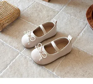 Primer plano detallado de zapatos Mary Jane beige para niñas con lazo y correa